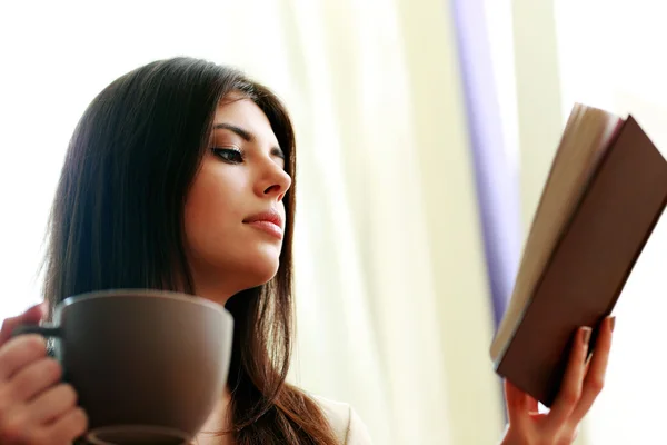 Mujer con taza de libro de lectura de café — Foto de Stock