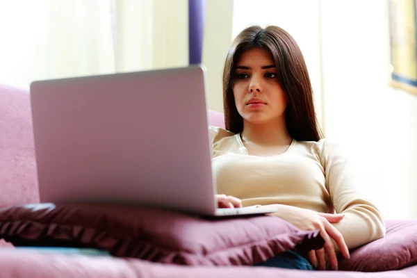 Žena pomocí přenosného počítače na pohovce — Stock fotografie