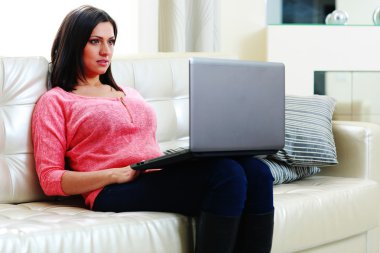 dizüstü bilgisayar ile kanepede oturan kadın