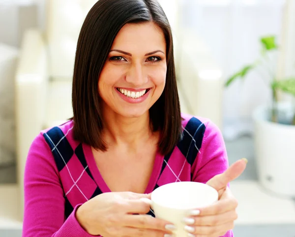 Mujer alegre sosteniendo una taza de café — Foto de Stock