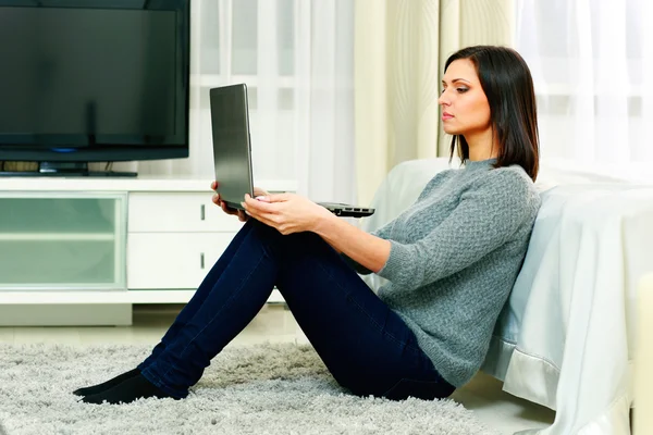 Frau sitzt auf dem Boden und benutzt Laptop — Stockfoto