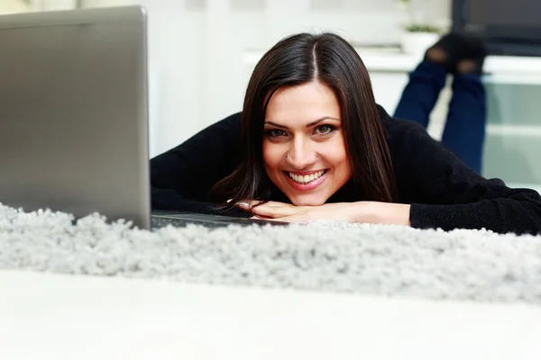 Femme couchée avec ordinateur portable à la maison — Photo