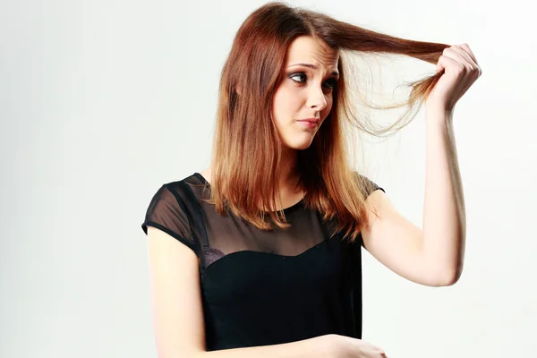 Junge nachdenkliche Frau berührt ihre Haare — Stockfoto