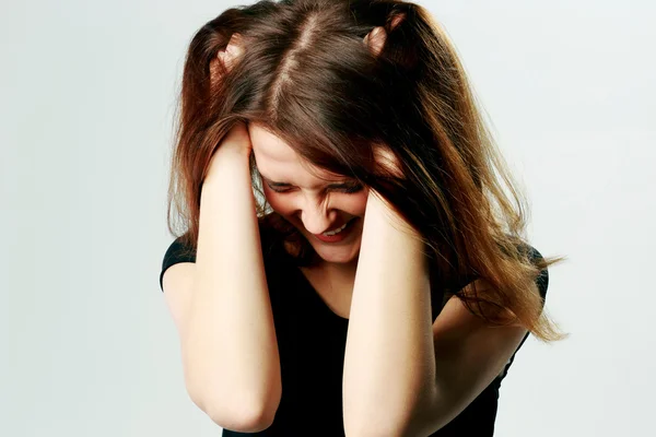 Joven mujer gritando tirando de su pelo — Foto de Stock