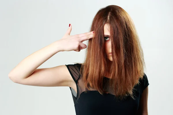 Vrouw schieten zichzelf met vinger — Stockfoto