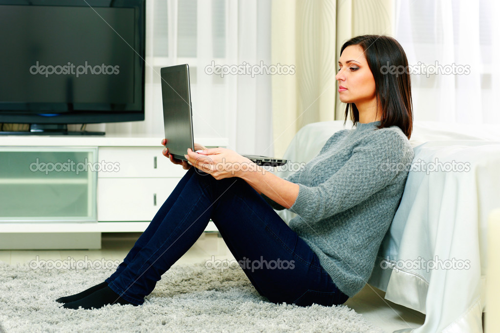Woman sitting on the floor and using laptop