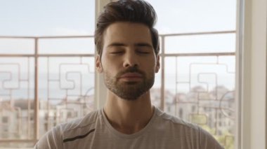 Gülümseyen adamın evde derin bir nefes alışının yakın görüntüsü.