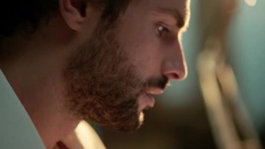 Geceleri ofiste çalışan neşeli adamın yakın çekim görüntüsü.