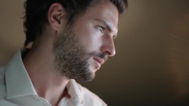 Ofiste çalışan yakışıklı, konsantre bir adamın yakın çekimi.