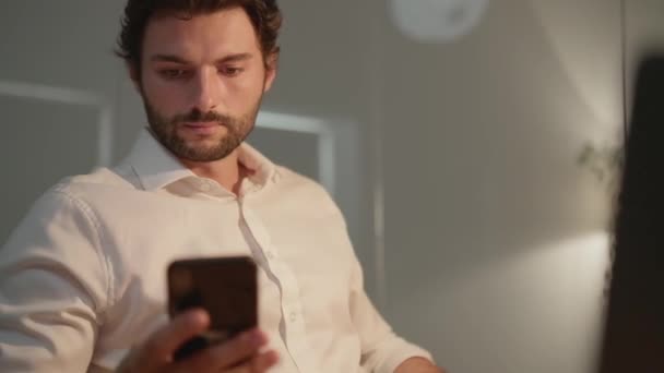 Ένας Συγκεντρωμένος Άντρας Κοιτάζει Τηλέφωνο Στο Γραφείο Νύχτα — Αρχείο Βίντεο