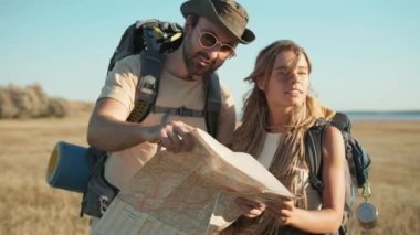 Nehir kenarındaki haritaya bakan pozitif turist çifti