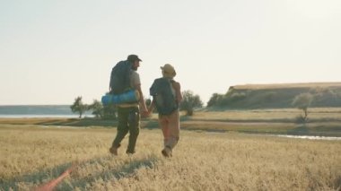 Nehir kenarında el ele tutuşan yakışıklı turistlerin arka manzarası.