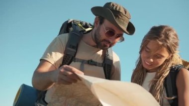 Nehir kenarındaki haritaya bakan yakışıklı turistlerin alt manzarası.