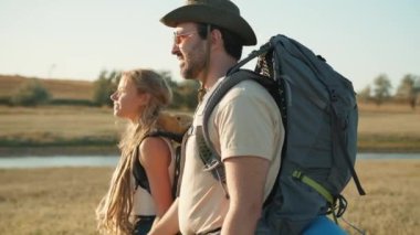 Nehir kenarında yürüyen konsantre turistlerin yan görüntüsü