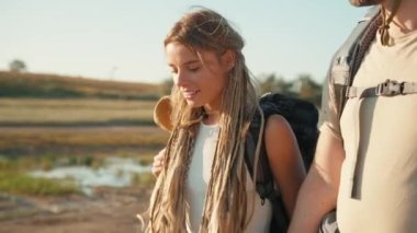 Erkek arkadaşıyla nehir kenarında yürürken gülümseyen turist kadının yakın görüntüsü.
