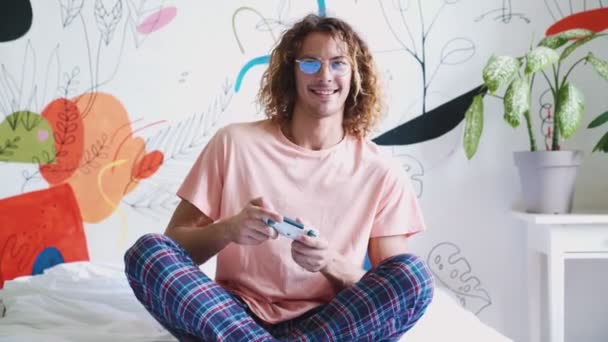 Gamepad Oyun Oynayan Uzun Saçlı Gülümseyen Yatakta Otururken Kazanan Bir — Stok video