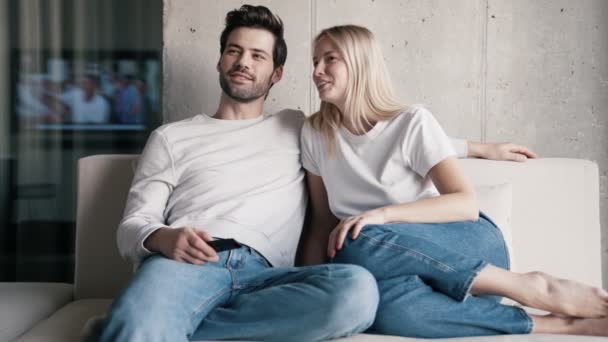Lächelndes Paar Vor Dem Fernseher Und Hause Gespräch — Stockvideo