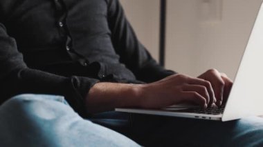 Ciddi bir iş adamının dizüstü bilgisayarda yazı yazıp gözlüklerini çıkardığı yakın plan görüntüler.