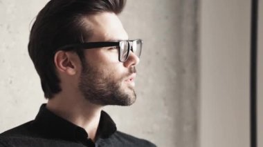 Gözlüklü gülümseyen yakışıklı iş adamının yakın çekim görüntüsü. Evdeki not defterine bir şey yazıyor.