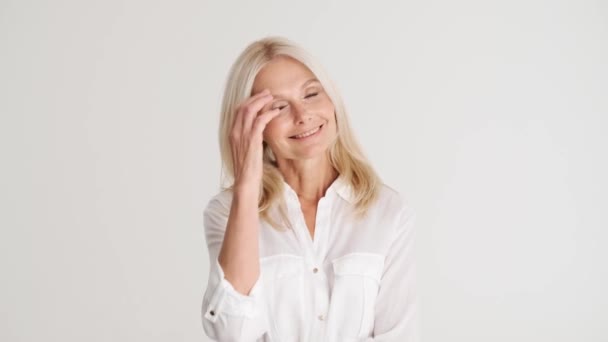 Mujer Madura Guapo Positivo Corrigiendo Peinado Mirando Cámara Estudio Blanco — Vídeos de Stock