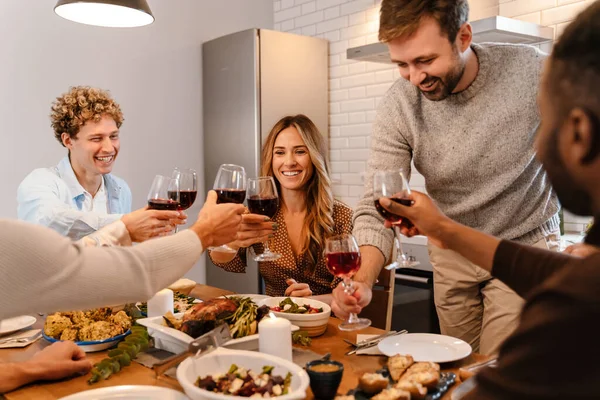 Memlekette şükran günü yemeğinde şarap içen çok ırklı mutlu arkadaşlar.