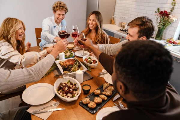 Memlekette şükran günü yemeğinde şarap içen çok ırklı mutlu arkadaşlar.