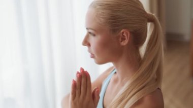 Kendine güvenen bir kadının evde yoga yaparken görüntüsü.