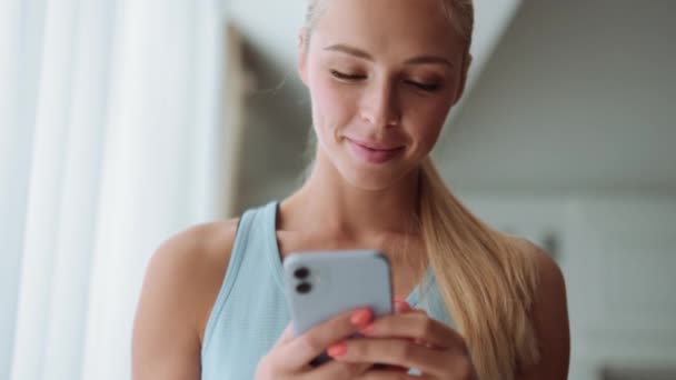 Mujer Rubia Positiva Mensajes Texto Por Teléfono Mirando Lado Casa — Vídeo de stock