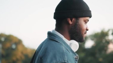 Kulaklıklı kendine güvenen bir Afrikalı sokak manzarasına bakıyor.