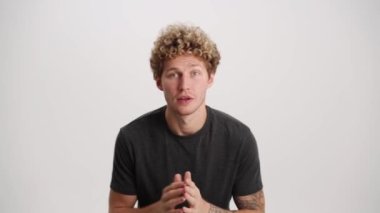 Maçı takip eden konsantre adam ve beyaz stüdyoda kazanan jest yapıyor.