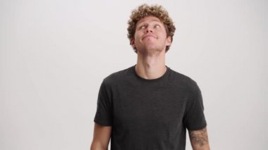 Yorgun adam esniyor ve beyaz stüdyoda etrafa bakıyor.