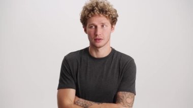 Hayal kırıklığına uğramış bir adam beyaz stüdyoda facepalm hareketi yapıyor.