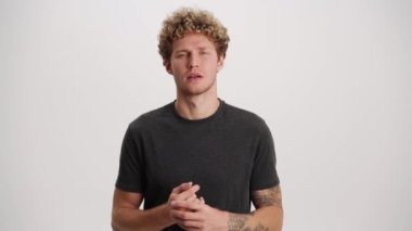 Düşünceli adam beyaz stüdyoda baş parmak hareketi yapıyor.