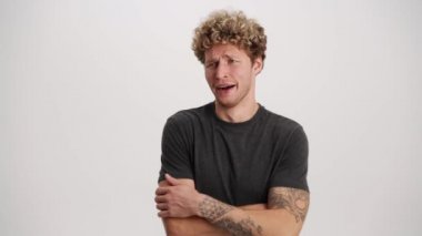 Sıkılmış adam beyaz stüdyoda esniyor.