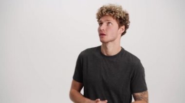 Kendine güveni olan adam beyaz stüdyoda dinleyicileri dinleyip başını sallıyor.