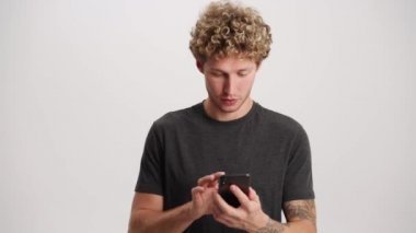 Telefonla konuşan kıvırcık saçlı adam ve beyaz stüdyoda hava öpücüğü veren adam.