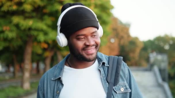 Fröhlicher Afrikaner Hört Musik Über Kopfhörer Während Auf Der Straße — Stockvideo