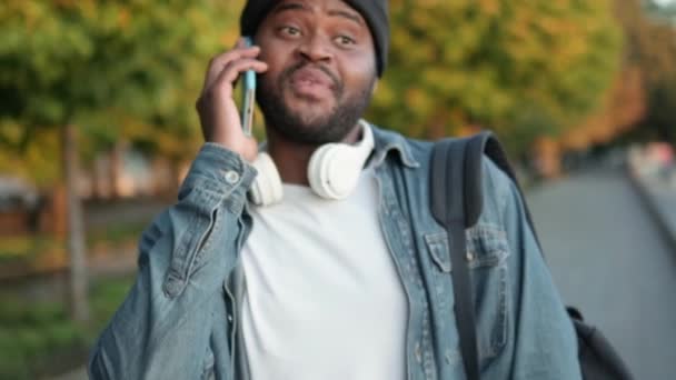 Χαμογελώντας Αφρικανός Που Μιλάει Στο Τηλέφωνο Ενώ Περπατάει Στο Δρόμο — Αρχείο Βίντεο