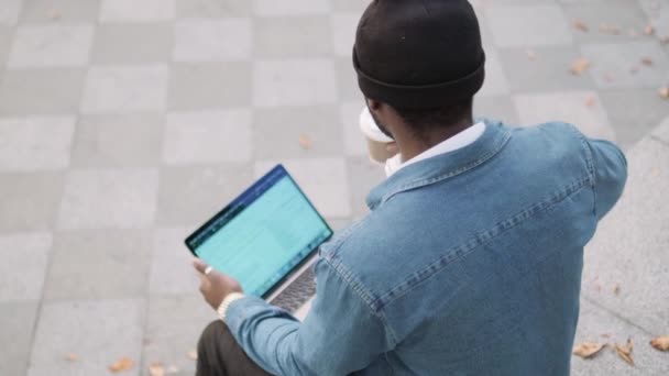 Vista Superior Homem Africano Fones Ouvido Trabalhando Laptop Bebendo Café — Vídeo de Stock