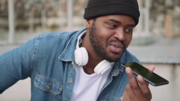 Vue Rapprochée Africain Positif Dans Casque Enregistrant Message Vocal Téléphone — Video