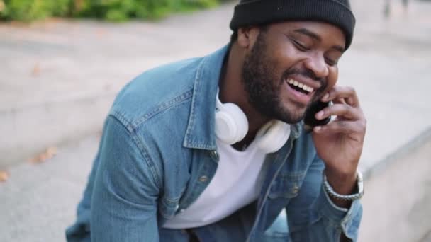 Γκρο Πλαν Άποψη Του Χαμογελαστού Αφρικανού Ακουστικά Μιλώντας Στο Τηλέφωνο — Αρχείο Βίντεο
