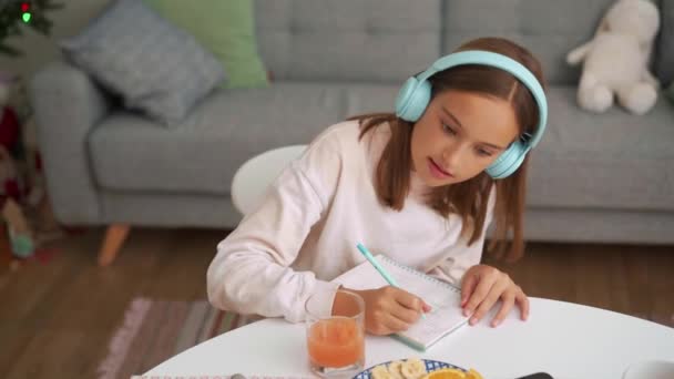 若い女の子の全体像ノートパッドで何かを描くキッチンで — ストック動画