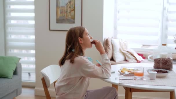 Chica Positiva Comiendo Galletas Cuando Mamá Viene Hablando Con Ella — Vídeos de Stock