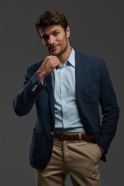 Genç, güzel, sinsi ve düşünceli Avrupalı iş adamı. Siyah saçlı, sakallı bir adam, sıradan bir ceket giyer. Koyu gri arka planda izole edilmiş. Stüdyo çekimi