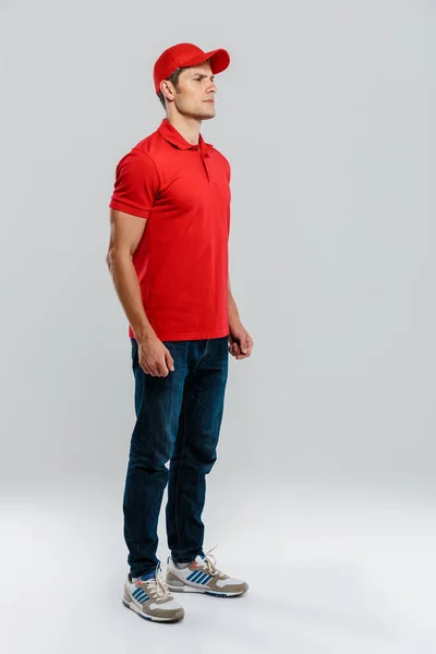 Jovem Entrega Homem Vestindo Uniforme Posando Olhando Para Lado Isolado — Fotografia de Stock