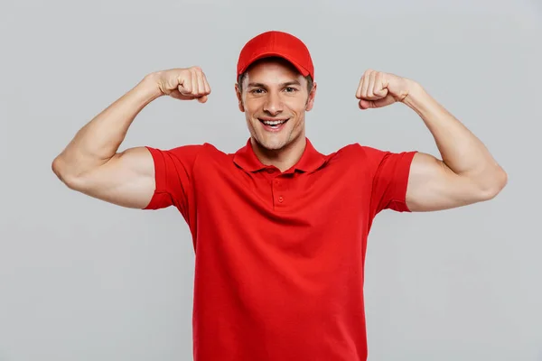 Young Delivery Man Wearing Uniform Smiling While Showing His Biceps — Stock Photo, Image