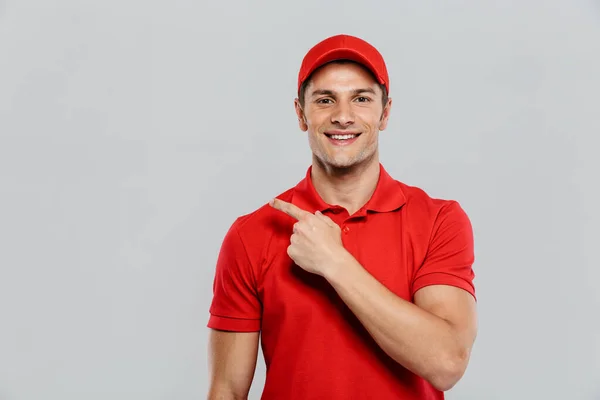 Jovem Homem Entrega Vestindo Uniforme Sorrindo Apontando Dedo Isolado Sobre — Fotografia de Stock