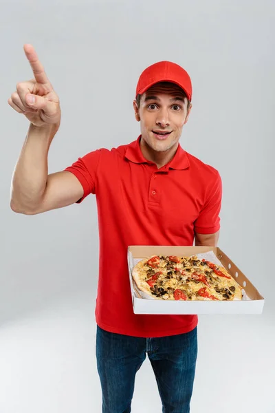 Jonge Bezorger Wijzende Vinger Naar Boven Terwijl Pizza Geïsoleerd Witte — Stockfoto