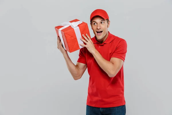 Junger Lieferant Mit Hut Lächelt Während Mit Geschenkbox Über Weißer — Stockfoto