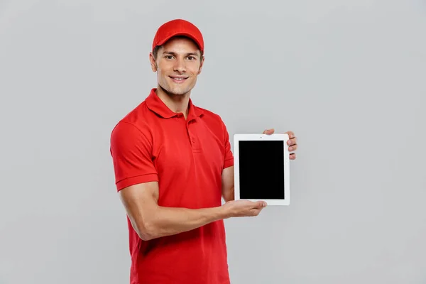 Jovem Homem Entrega Uniforme Sorrindo Mostrar Computador Tablet Isolado Sobre — Fotografia de Stock